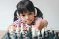 Asian little girl playing chess at home.a game of chess Royalty Free Stock Photo