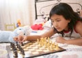 Asian little girl playing chess with teddy rabbit Royalty Free Stock Photo