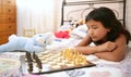 Asian little girl playing chess with teddy rabbit Royalty Free Stock Photo