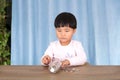 Asian little girl playing with dollar coins in a glass bottle Royalty Free Stock Photo