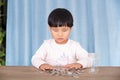 Asian little girl playing with dollar coins in glass bottle Royalty Free Stock Photo