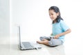 Asian little girl playing games with laptop computer and joystick controller