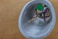 Asian little girl playing inside a tunnel in the park for children