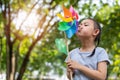 Asian little girl playing with paper windmill