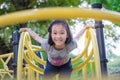 Asian little girl is playing on a playground outdoor and looking at camera in the park,summer,vacation concept Royalty Free Stock Photo