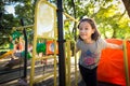 Asian little girl is playing on a playground outdoor and looking at camera in the park,summer,vacation concept Royalty Free Stock Photo