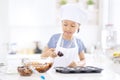 Asian little girl pouring chocolate dough on mold