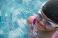 Asian little girl practice swimming for match in swimming pool. Little girl cheerful in this activity.She hard practice swimming b Royalty Free Stock Photo