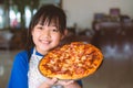 Asian little girl preparing homemade pizza with smile and happy Royalty Free Stock Photo