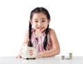 Asian little girl saving money in a piggy bank. Isolated on white background Royalty Free Stock Photo