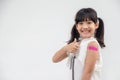 Asian little girl showing his arm after got vaccinated or inoculation, child immunization, covid delta vaccine concept
