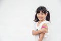 Asian little girl showing his arm after got vaccinated or inoculation, child immunization, covid delta vaccine concept