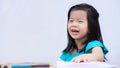 Asian little girl sits at the back of a study table wood. Children are laughing and having fun in art class. Royalty Free Stock Photo