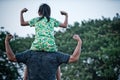 Asian little girl sitting on her father shoulders and make gestures action strong with smile and happy.Concept of fathers day