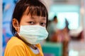 Asian little girl sitting in a hospital and wear  medical mask with sad eyes and hope . Coronavirus Covid-19 concept Royalty Free Stock Photo