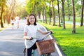 Asian little girl is smiling and looking at the camera on the bike in outdoor park,portrait of happy cute child with bicycle, Royalty Free Stock Photo