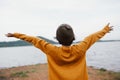 Asian little girl stood looking at the river in the embankment while raising her hand up in the morning winter