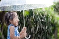 Asian little girl with umbrella in rain Royalty Free Stock Photo