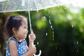 Asian little girl with umbrella in rain Royalty Free Stock Photo