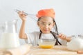Asian little girl using stainless steel whisk to mix the egg for Royalty Free Stock Photo