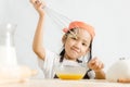 Asian little girl using stainless steel whisk to mix the egg for Royalty Free Stock Photo