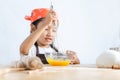 Asian little girl using stainless steel whisk to mix the egg for Royalty Free Stock Photo