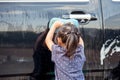 Asian little girl washing car Royalty Free Stock Photo