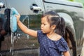 Asian little girl washing car Royalty Free Stock Photo