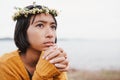 Asian little girl wears a flower crown while sit looking the nature on the weekend day