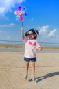 Asian little girl with wind turbine toy in hands Royalty Free Stock Photo