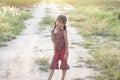 Asian little girl wore a dress made of Thai loincloth or Kamar band or Commer band standing and smile bright in the fields.