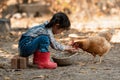 Asian little girl and young woman feed the chicken in layer and house farm eggs.