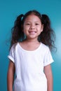 Asian little kid girl smile happiness portrait looking at the camera on green background