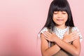 Asian little kid 10 years old doing grateful gesture and closed eyes Royalty Free Stock Photo