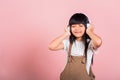 Asian little kid 10 years old smiling listening music wearing wireless headset Royalty Free Stock Photo