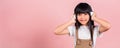Asian little kid 10 years old smiling listening music wearing wireless headset on her head Royalty Free Stock Photo