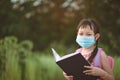 Asian little school girl reading book with wearing face mask.Back to school concept Royalty Free Stock Photo