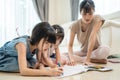 Asian Little siblings girl draw and color picture with mother on floor. Beautiful loving parent, mom spend time with small cute