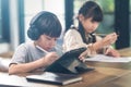 Asian little young children self learning at home. The boy using tablet and headphones for E-learning at home. The girl doing home Royalty Free Stock Photo