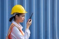 Asian Logistic Worker woman in Uniform Talking on Walkie Talkie to Communicate with Other Workers