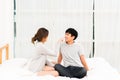 Asian lovely couple flirting together on bed in white bedroom. Girlfriend and boyfriend teasing each other Royalty Free Stock Photo