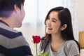 Asian lovely couple man and woman in bedroom together. Boyfriend give rose to girlfriend in romantic moment of love. Warm heart ma