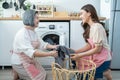 Asian lovely family doing house working and chores in kitchen at home. Young girl daughter help and support senior old mother put Royalty Free Stock Photo