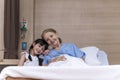 Lovely girl visit and encourage grandmother on patient bed in hospital Royalty Free Stock Photo