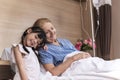 Lovely girl visit and encourage grandmother on patient bed in hospital Royalty Free Stock Photo