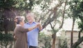 Asian lovely happy senior couple grandfather and grandmother dancing or hugging outside of home. Joyful elderly smiling retired Royalty Free Stock Photo