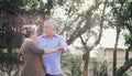 Asian lovely happy senior couple grandfather and grandmother dancing or hugging outside of home. Joyful elderly smiling retired Royalty Free Stock Photo