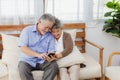 Asian lovely happy senior couple grandfather and grandmother hugging or cuddling on sofa in living room at home. Joyful elderly