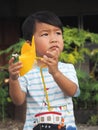 Asian lovely kid holding a yellow windmill toy with natural background.