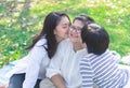 Asian lovely young daughter and grandson kiss happy and healthly senior woman or pleasure grandmother in moment of beautiful love